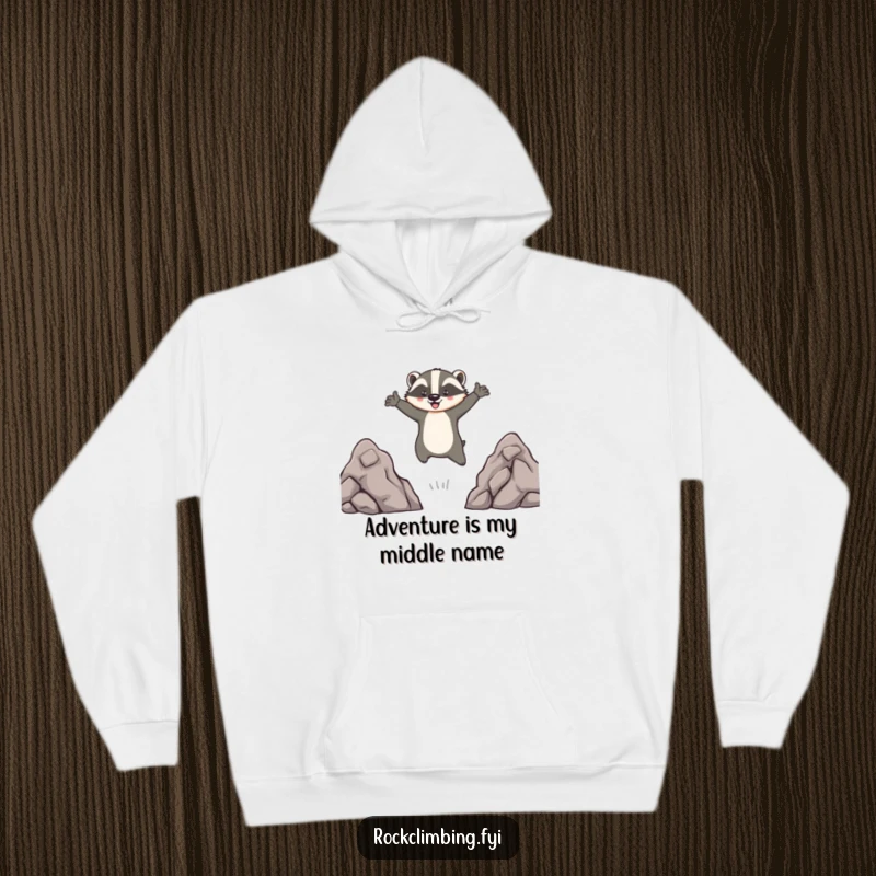 Funny hoodie with a brave badger leaping across rocks, arms out, in a comical adventure scene, perfect comfort wear for thrill-seekers.