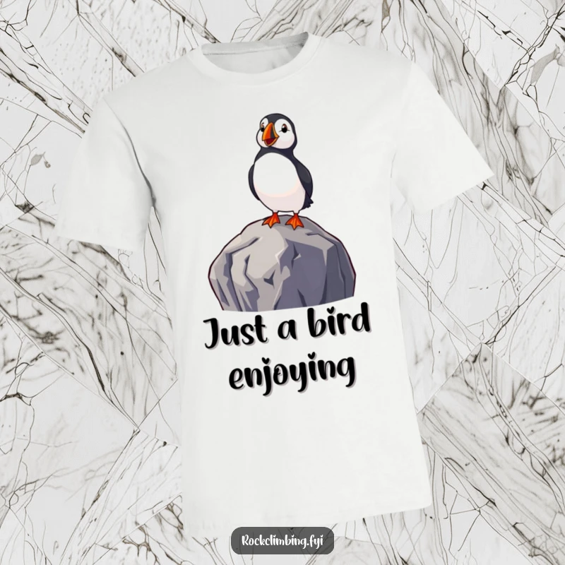 Funny t-shirt depicting a delighted puffin perched on a rock overlooking the sea, capturing a moment of peaceful, humorous observation.